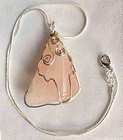 Full view of necklace showing rose quartz pendant and snake chain