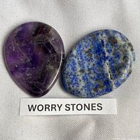 Front view of both worry stones on fabric with label
