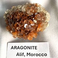 Top view of aragonite cluster displaying brown and white crystals with label