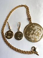Necklace and earrings laid out showing design and clasp