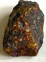 Rough chalcopyrite specimen showing brassy yellow and iridescent colours