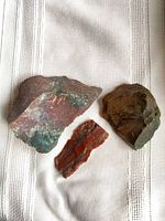 Three chert pieces on cloth background with coin for scale