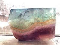 angled view of polished fluorite showing multicolour bands