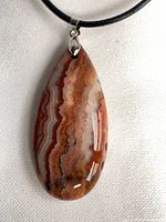 Front view of agate pendant on black cord