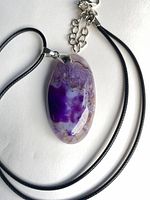 Front view of purple druzy agate pendant on black cord