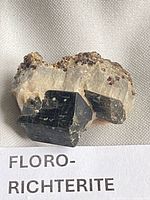 Front view showing black prismatic crystals and beige matrix