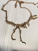 Full view of gold-tone dinosaur skeleton necklace