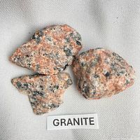 Three granite pieces labeled GRANITE on neutral fabric background