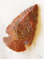 Front view of brown-red stone arrowhead