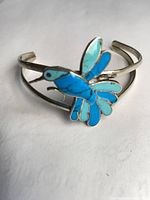 Full view of cuff bracelet showing hummingbird inlay and double-band design