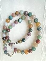 Full view of necklace coiled showing multicolour 8 mm beads and clasp