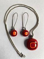 Necklace and earrings laid flat to show design and chain clasp