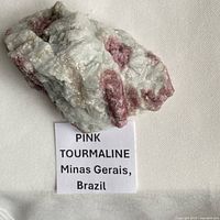 Specimen with printed label identifying pink tourmaline origin