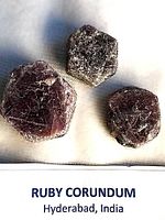 Three ruby corundum crystals on fabric background