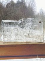 Front view of transparent selenite slab showing striations and drilled hole