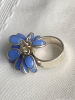 Side view of silver ring showing blue dangling charms
