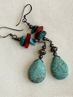 Both earrings laid out showing turquoise howlite drops, red/turquoise chips, metal spacers, hooks