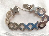 Top view displaying alternating X and O links and clasp with safety chain