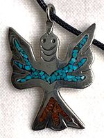 Front view of sterling bird pendant showing turquoise and coral inlay