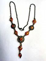 Full view of necklace laid flat showing chain, links and drop