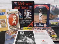 Group shot showcasing figure, books, programs, sticker album