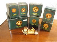 Seven green Boyds Collection boxes and one loose figurine group on table