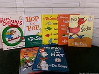 Front view showing all seven book covers upright and two lying flat