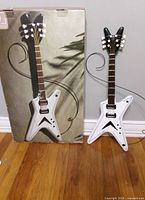 Replica Dean ML guitar wall art next to original box