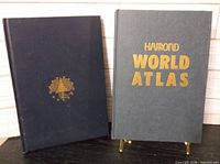 Front covers of both hardcover atlases standing upright