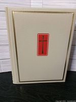 Front cover of cream faux-leather Holy Bible with red cross inset