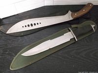 Both knives side by side in sheaths on dark surface