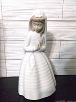 Front view of NAO porcelain praying girl figurine showing clasped hands, veiled dress, rosary