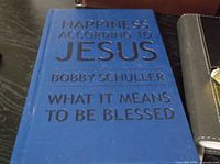 Blue hardcover book titled “Happiness According To Jesus” by Bobby Schuller