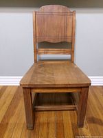 Front view of oak chair showing backrest carving, seat, legs