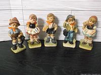 Front view of all five ceramic child figurines