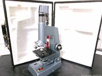 Microscope standing in front of open fitted case