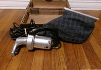 Full view of handheld vacuum with cloth bag and storage case