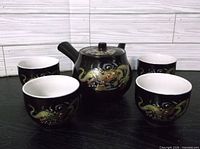 full set showing teapot and four cups front view