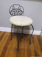 Full view of black metal vanity chair with cushion