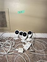 Four EZVIZ cameras with attached cables and USB adapters on floor