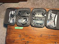 Both open cases showing drones, controllers, accessories