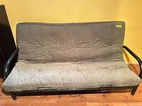 Front view of gray futon sofa bed with metal frame