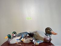 Front view of five carved wooden duck decoys on table