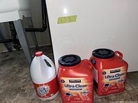 Two Kirkland Ultra Clean detergent pails and one Old Dutch bleach jug grouped together