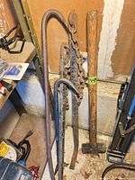 Group of hammer, pry bars and chain leaning against wall