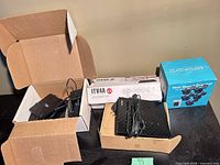 Overview showing ITV4A box, Asus router, blue Blink bracket box, open box of adapters