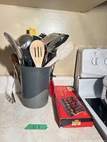 Utensils grouped in holder beside boxed Fiesta Grill Gear skewers