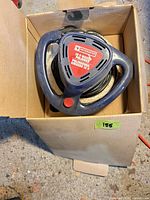 Waxer/polisher in open box showing handles and pad