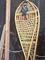 Full view of one snowshoe showing wood frame and rawhide webbing