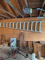 Full view of aluminum folding ladder hanging in garage
